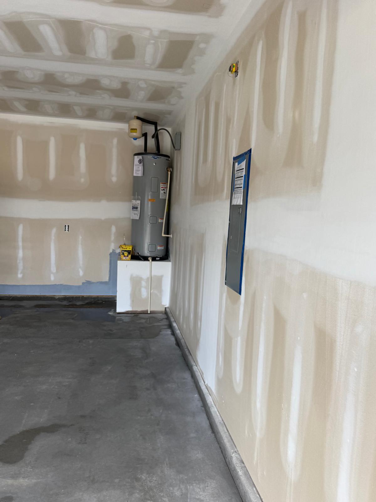 Unpainted garage wall and water heater before work