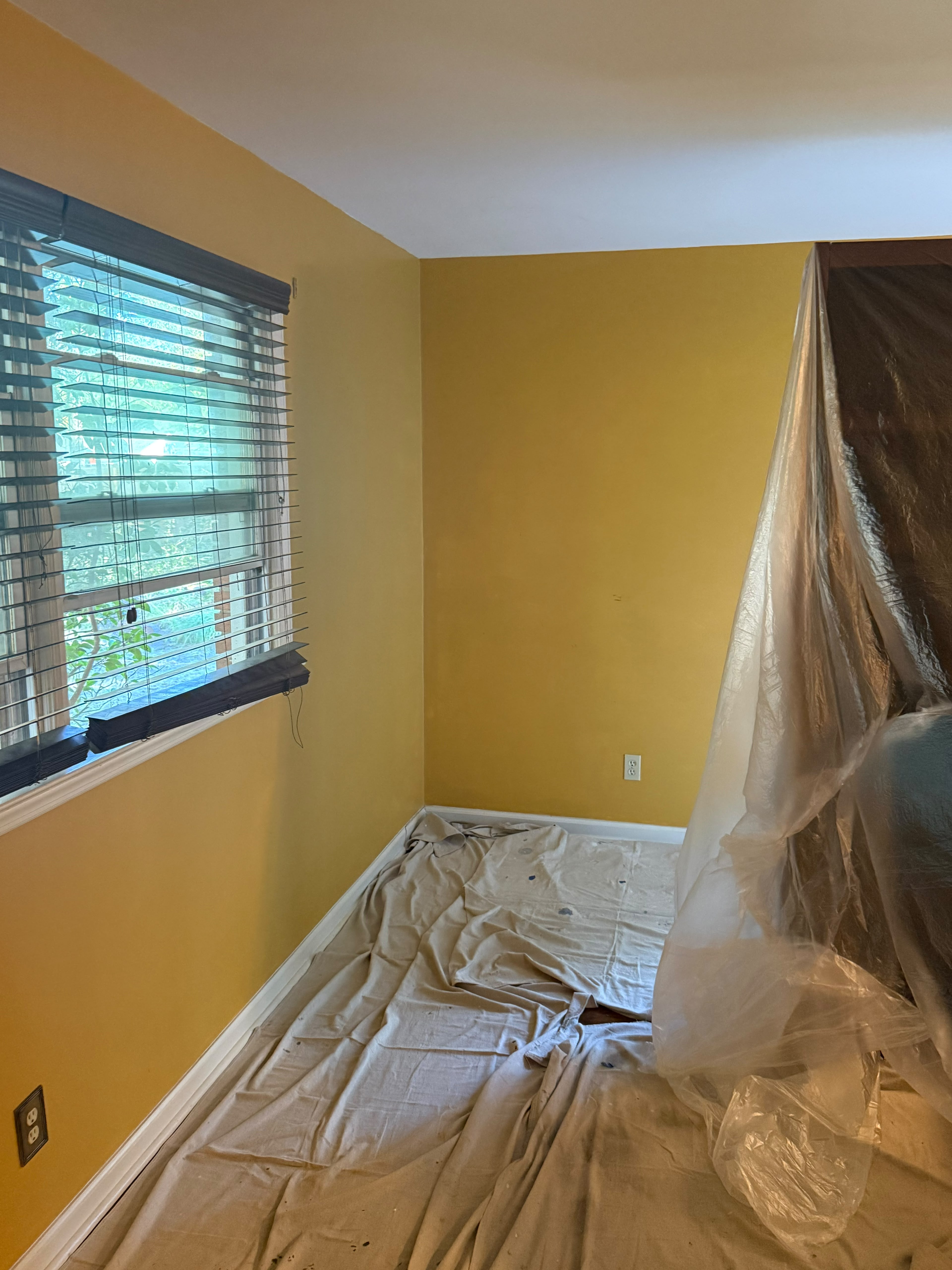 Painter testing green sample over gold wall